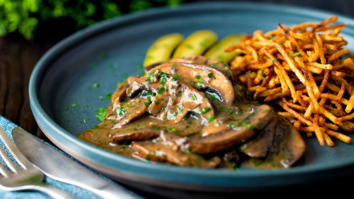 Easy vegan mushroom stroganoff served with pickles and matchstick potatoes.