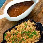 Overhead vegan onion gravy served in a gravy boat with a vegetable crumble.