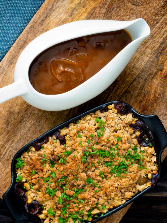 Overhead vegan onion gravy served in a gravy boat with a vegetable crumble.