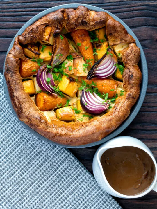 Overhead vegan onion gravy served with a vegetable toad in the hole.