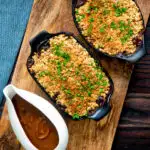 Overhead root vegetable crumble with an oaty crumb with a vegan onion gravy featuring a title overlay.