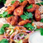 Amritsari fish pakora served with chapatis, chunky kachumber salad and raita featuring a title overlay.