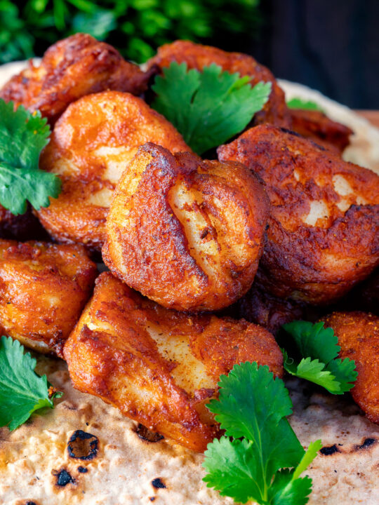 Close up Amritsari fish pakora served with chapatis and coriander.