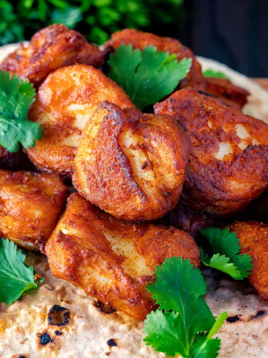 Close up Amritsari fish pakora served with chapatis and coriander.