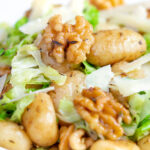 Close up cabbage and walnut gnocchi served with parmesan shavings.