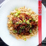 Overhead Chinese takeaway style crispy orange chicken with egg fried rice.