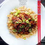 Overhead Chinese takeaway style crispy orange chicken with egg fried rice featuring a title overlay.