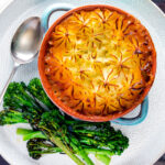 Overhead traditional British mince beef cottage pie served in a blue earthenware bowl.
