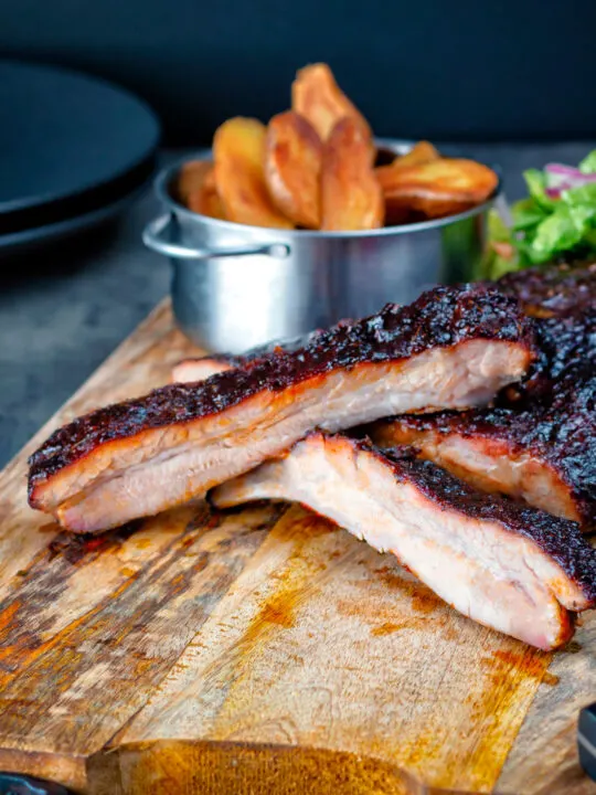 Oven baked sticky BBQ pork ribs served with salad and wedges.