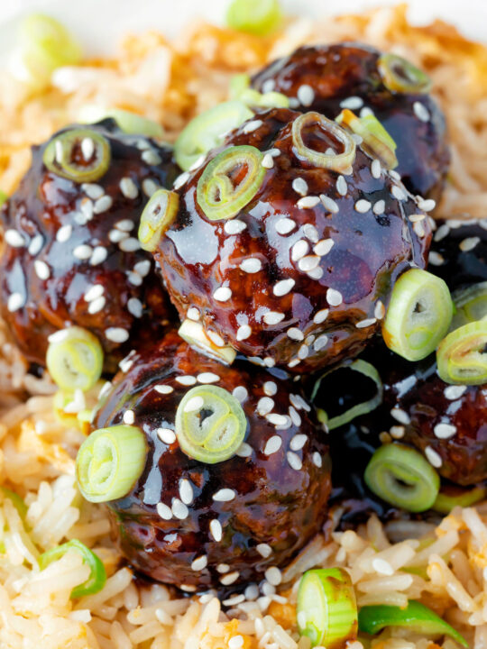 Close up easy teriyaki glazed beef meatballs with egg fried rice featuring a title overlay.