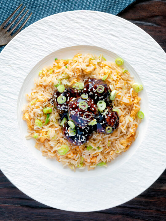 Overhead easy teriyaki glazed beef meatballs with egg fried rice.