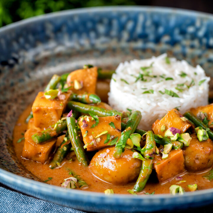 Vegan Thai massaman curry with potatoes, green beans, pistachio nuts and rice.