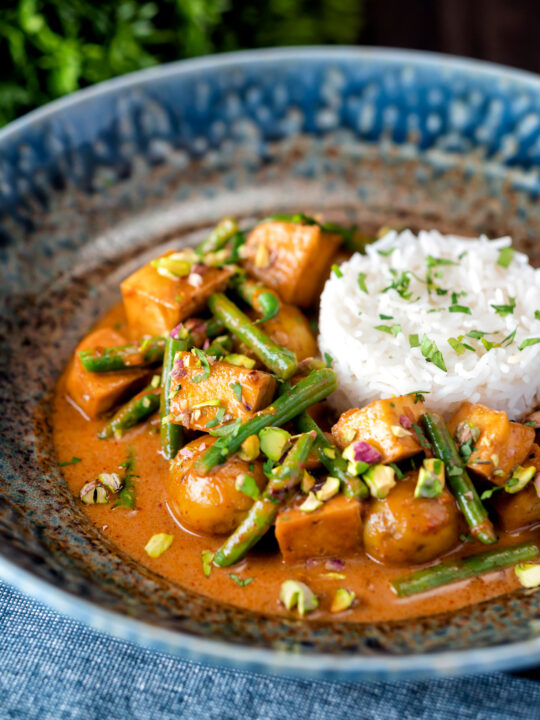 Vegan Thai massaman curry with potatoes, green beans and pistachio nuts.