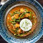 Overhead vegan Thai massaman curry with potatoes, green beans and pistachio nuts.