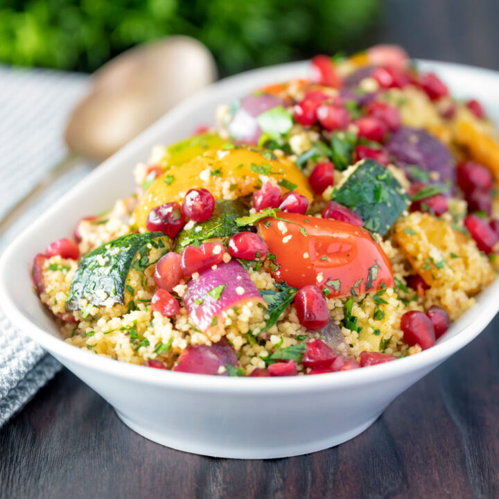 Vegetarian roasted vegetable couscous salad with fresh herbs and pomegranate arils.