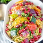 Vegetarian roasted vegetable couscous salad with pomegranate arils.