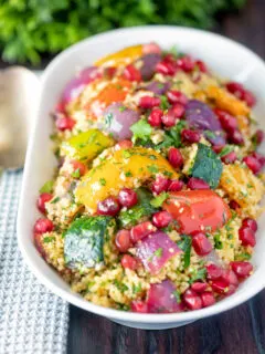 Vegetarian roasted vegetable couscous salad with pomegranate arils.