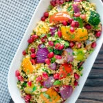 Overhead vegetarian roasted vegetable couscous salad with pomegranate arils.