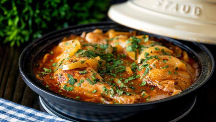 Moroccan Chicken tagine with preserved lemon and harissa cooked in a tagine pot.