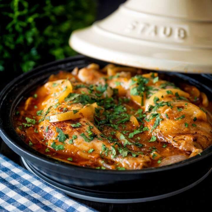 Moroccan Chicken tagine with preserved lemon and harissa cooked in a tagine pot.