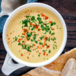 Overhead cream of celeriac soup served in a cup with bread.