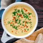 Overhead cream of celeriac soup served in a cup with bread featuring a title overlay.