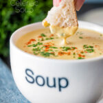 Bread being dipped into a cream of celeriac soup served in a cup featuring a title overlay.