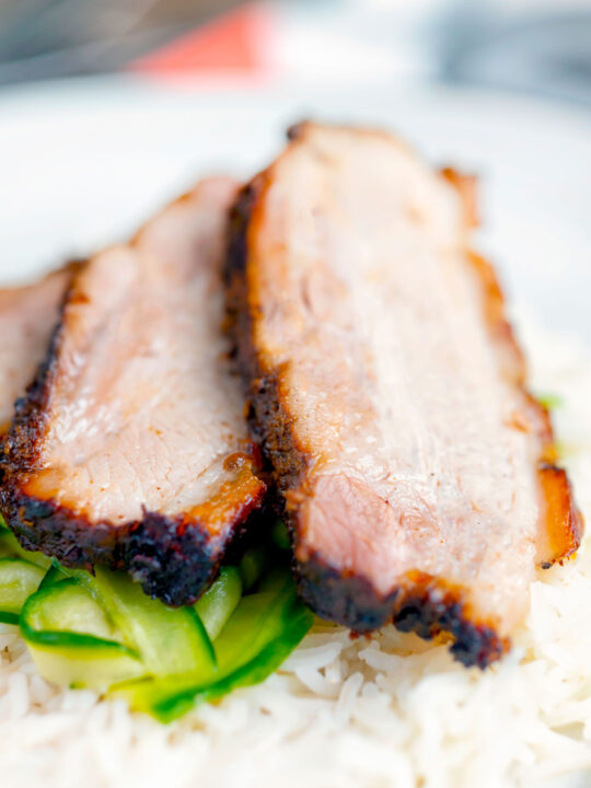 Sliced crispy Chinese Pork Belly served with rice and pickled cucumbers.