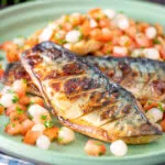 Devilled mackerel fillets served with a pickled onion and tomato salad.