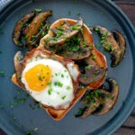 Overhead devilled mushrooms on toast with a fried egg.