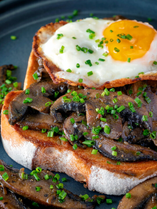 Close up devilled mushrooms on toast with a fried egg.