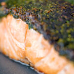 Close up baked herb crusted salmon fillet.