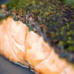 Close up baked herb crusted salmon fillet featuring a title overlay.