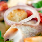 Close up smoked mackerel salad with apple, bacon and croutons.