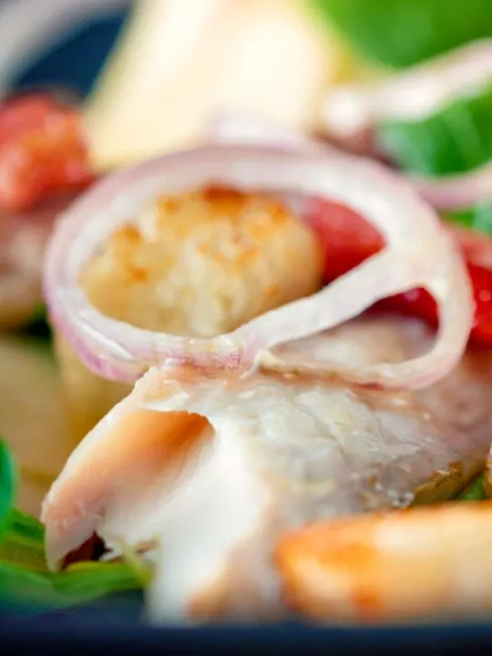 Close up smoked mackerel salad with apple, bacon and croutons.