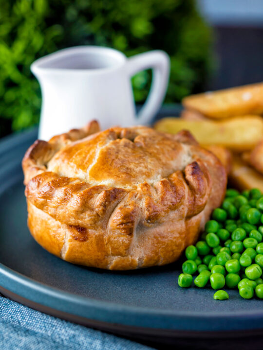 Hand raised steak and ale pie with chips and peas.