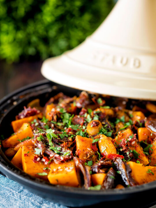 Sweet potato tagine with dates and almonds served in a tagine pot.