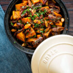 Overhead sweet potato tagine with dates and almonds served in a tagine pot.