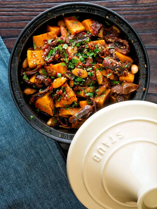 Overhead sweet potato tagine with dates and almonds served in a tagine pot.