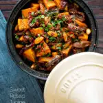 Overhead sweet potato tagine with dates and almonds served in a tagine pot with a title overlay.