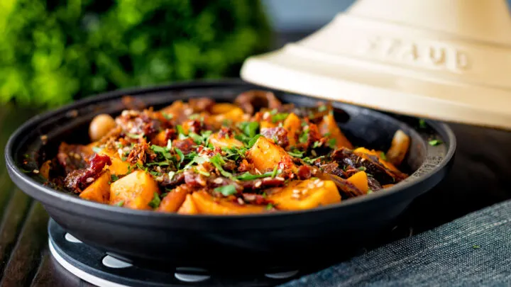 Vegan sweet potato tagine with dates and almonds in a harissa sauce.