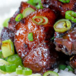 Close up Vietnamese pork belly influenced by thit ba chi kho served with rice featuring a title overlay.