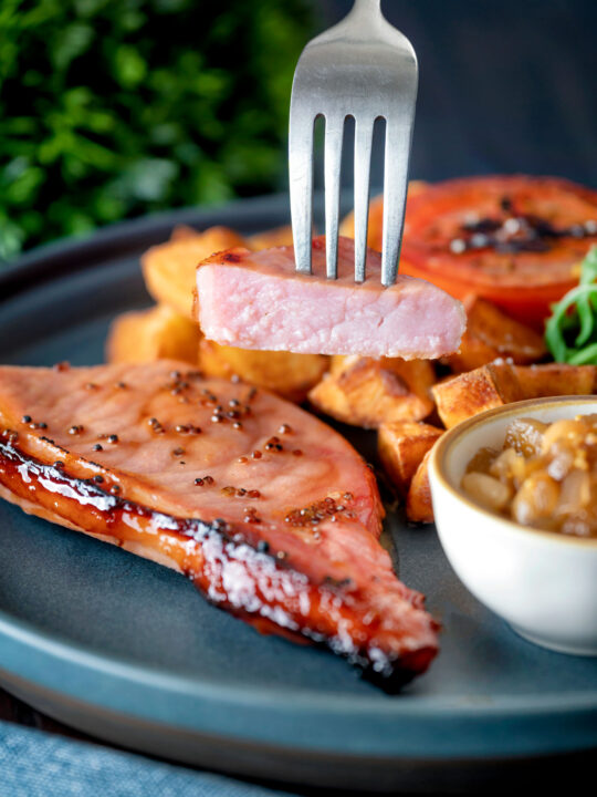 Cider glazed cut open bacon chops with fried potatoes, grilled tomato, rocket and apple chutney.