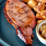 Cider glazed bacon chops with fried potatoes and apple chutney.
