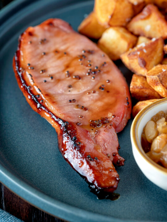 Cider glazed bacon chops with fried potatoes and apple chutney.