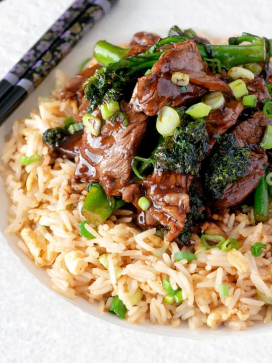 Close up beef and broccoli stir fry served with egg fried rice.