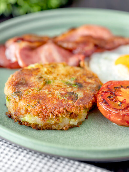 Fried bubble and squeak patty served with bacon, grilled tomato and fried egg.