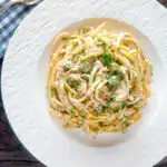 Overhead canned salmon linguini pasta with creme fraiche and cornichons.