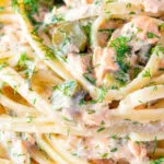 Close up tinned salmon pasta with creme fraiche, cornichons and fresh dill.