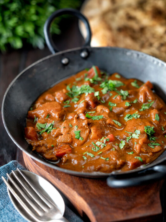 Chicken balti curry served in and iron karahi with fresh coriander.